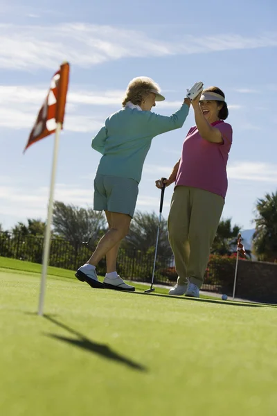 Kvinnor ger high-five på golfbana — Stockfoto