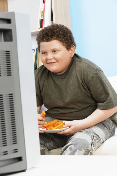 Niño con sobrepeso comiendo zanahoria —  Fotos de Stock