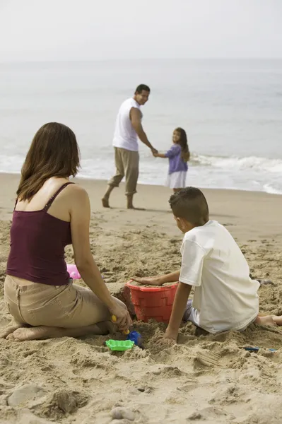 Família brincando na praia — Fotografia de Stock