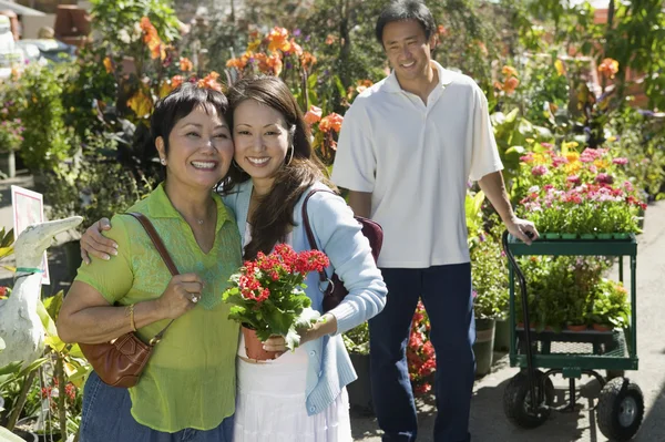 Mujer con madre en vivero de plantas — Foto de Stock