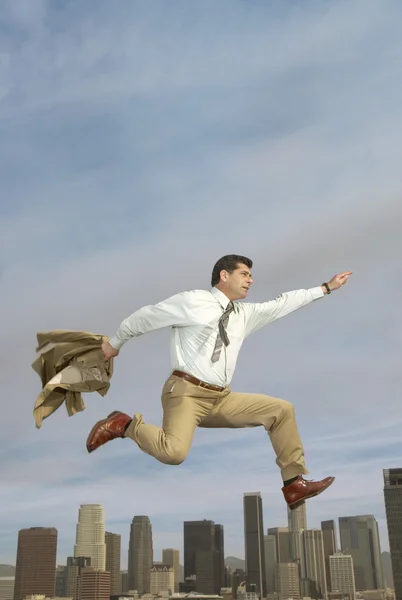 Businessman running with cityscape — Stock Photo, Image