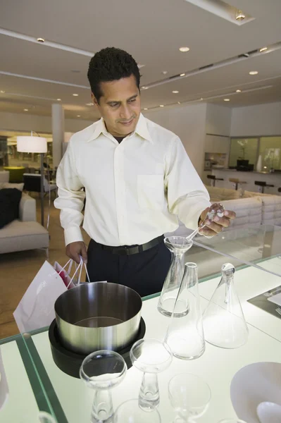 Hombre examinando utensilios de cocina — Foto de Stock