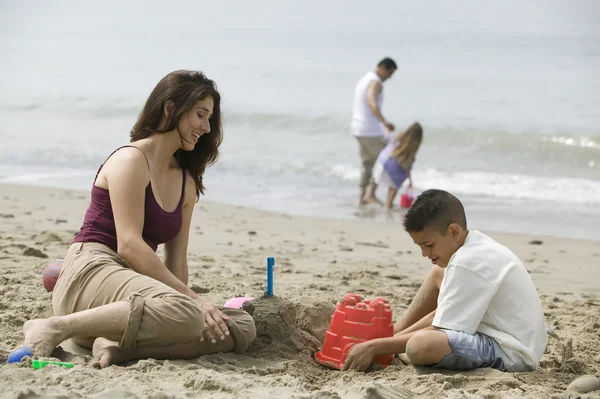 Мать строит песчаные замки с сыном — стоковое фото