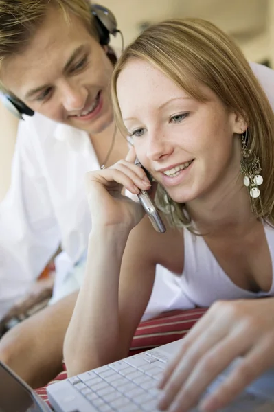 Par med hjälp av mobiltelefon och bärbar dator — Stockfoto