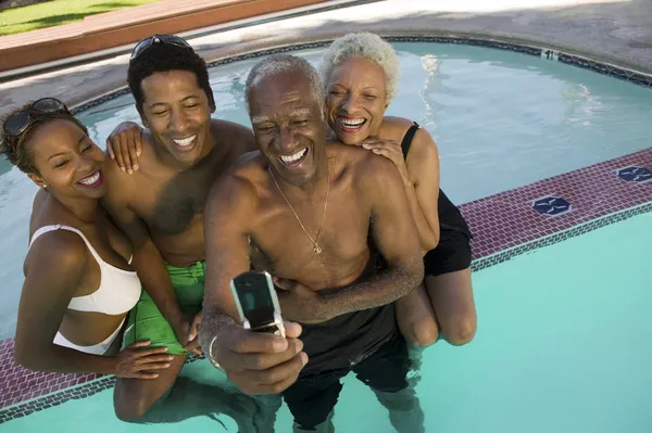 Posando família para foto do telefone da câmera na piscina — Fotografia de Stock