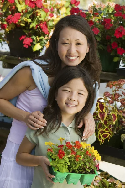 Mère avec fille tenant des fleurs — Photo