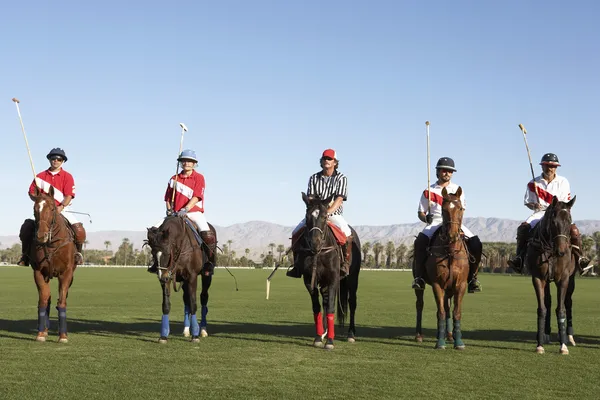 Игроки в поло и судья сидят на конях на поле — стоковое фото