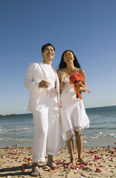 Sposi in piedi sulla spiaggia — Foto Stock