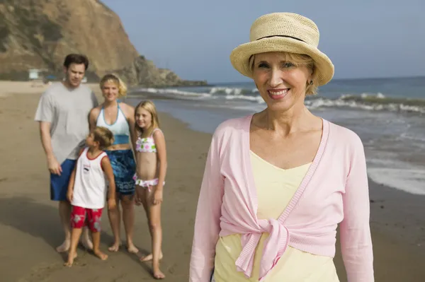 Grootmoeder met familie op strand — Stockfoto