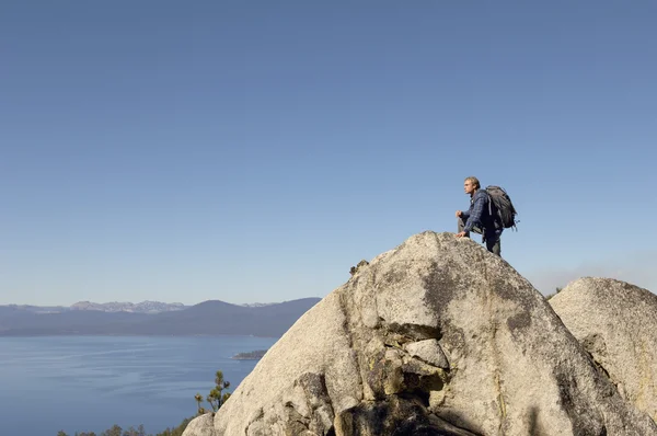 Hiker on boulder at coast — Stock Photo, Image