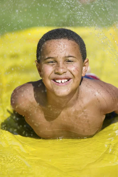 Junge rutscht auf Wasserrutsche — Stockfoto