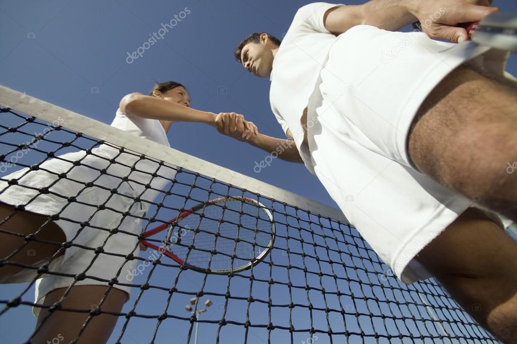 Shaking hands over tennis net