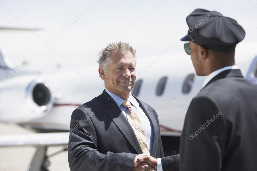 Businessman shaking hands with pilot