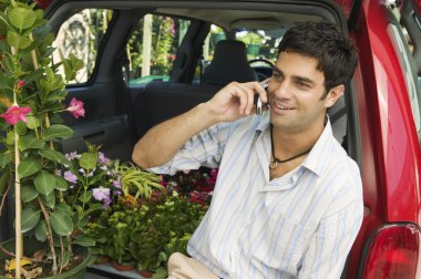 Man Using Cell Phone at Plant Nursery clipart