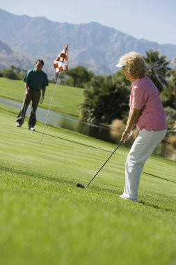 Golf oynayan yaşlı çift.