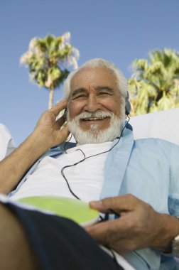 Senior Man listening to headphones clipart