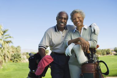 Senior couple in golf course smiling clipart