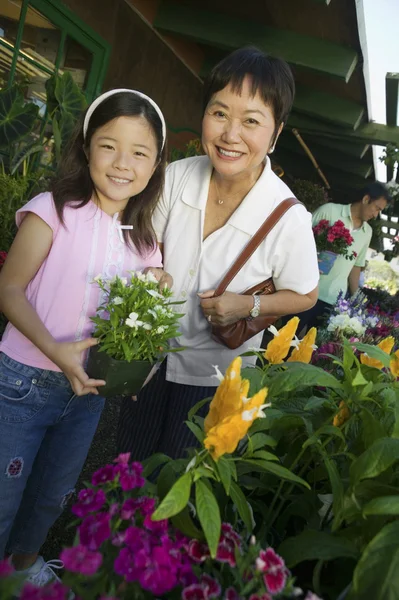Abuela y nieta en vivero de plantas — Foto de Stock