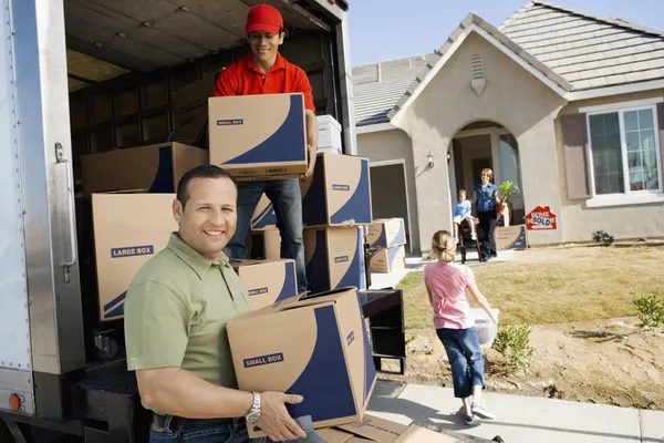 Familie en werknemer lossen levering van — Stockfoto