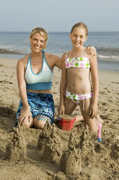 Mãe e filha construindo castelo de areia — Fotografia de Stock