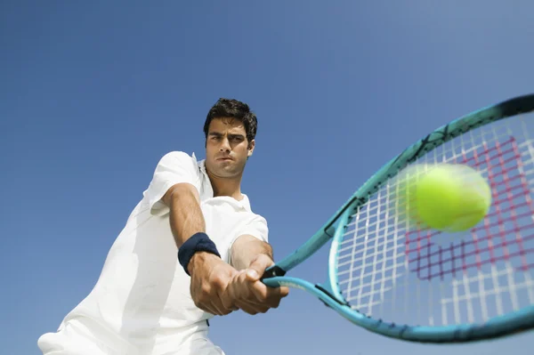 Теннисист бьет мяч — стоковое фото