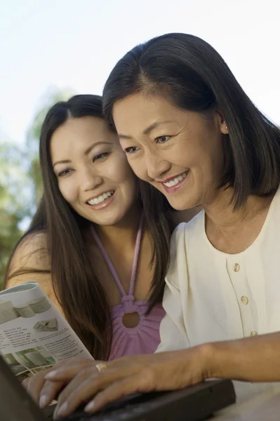 Madre e hija usando el ordenador portátil juntas — Foto de Stock