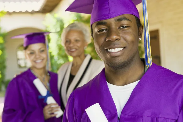 Graduates and Grandmother outdoors — Stock Photo, Image