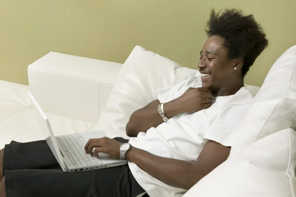 Man on sofa using laptop — Stock Photo, Image