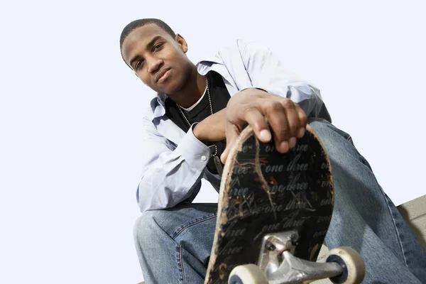 Man sitting with skateboard — Stock Photo, Image