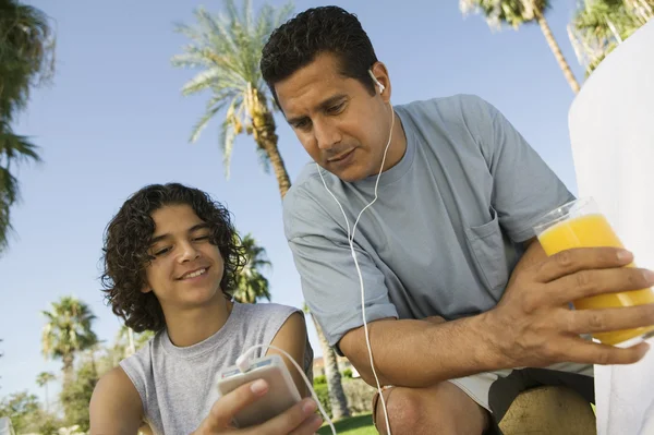 Far och son lyssnar på mp3-spelare — Stockfoto