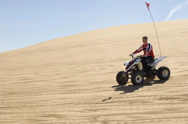 Man på atv på sanddyn — Stockfoto