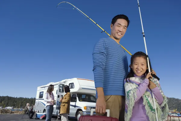 Baba ve kızı balıkçı direkleri tutarak — Stok fotoğraf