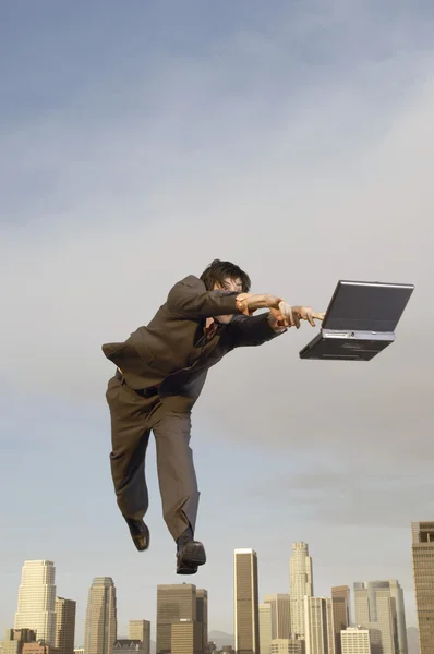 Businessman reaching for laptop — Stock Photo, Image