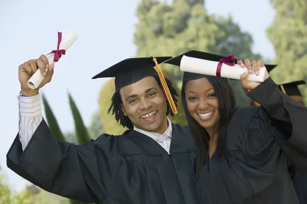 Two graduates hoisting diplomas — Stock Photo, Image