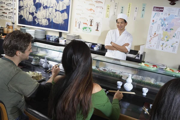 Mensen die eten in sushibar — Stockfoto