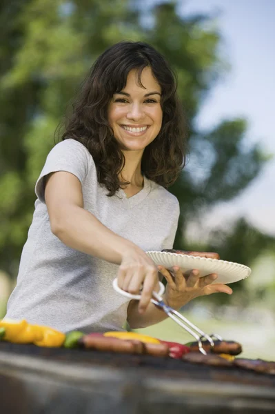 Kobieta grillowaniu potraw — Zdjęcie stockowe