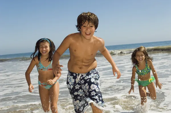 Children running through waves — Stock Photo, Image