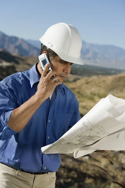 Pracownik budowlany przy użyciu telefonu komórkowego — Zdjęcie stockowe
