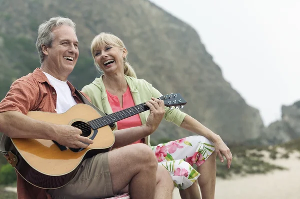 Мужчина играет на гитаре с женой — стоковое фото