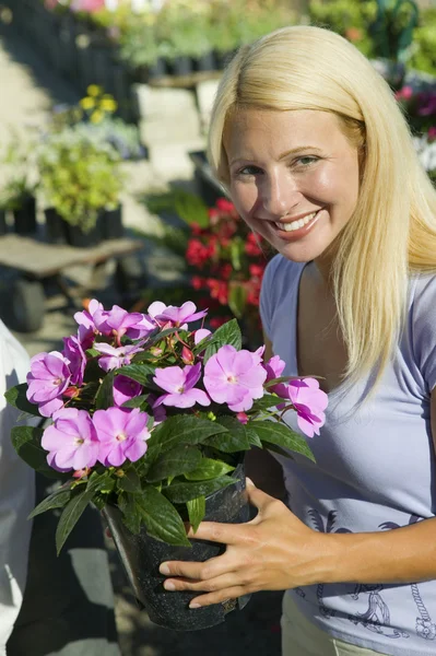 Kvinna anläggning blommor — Stockfoto
