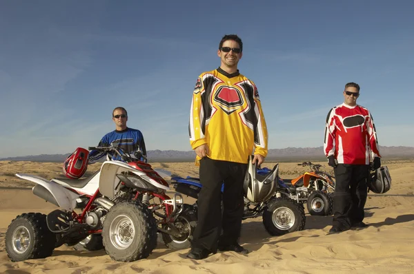 Homens em pé por quad bikes no deserto — Fotografia de Stock