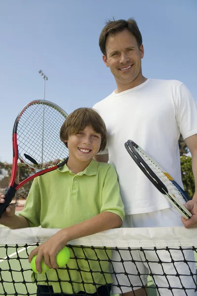 Far och son på tennis netto — Stockfoto