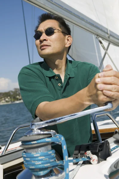 Uomo che alza la vela in barca a vela — Foto Stock