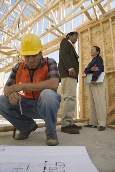 Construction worker looking at blueprints — Stock Photo, Image