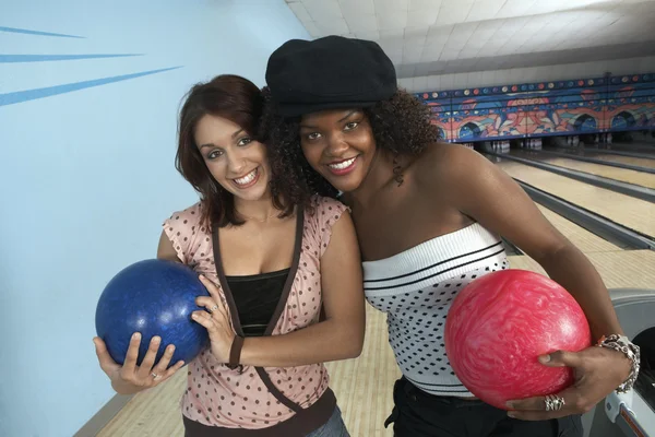 Friends with balls in bowling alley