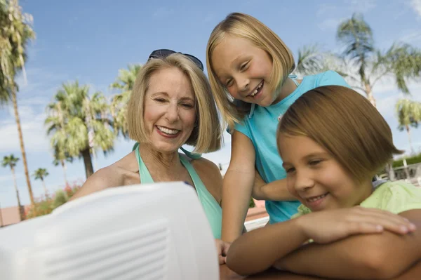 Flickor och mormor tittar på bärbara TV — Stockfoto