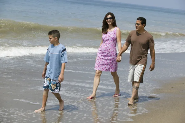 Familia caminando en la playa — Foto de Stock