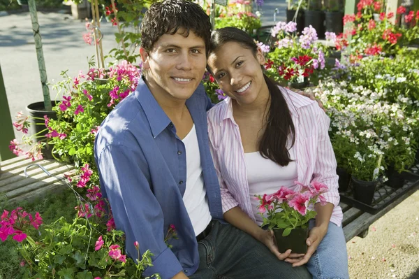 Casal sentado entre flores — Fotografia de Stock
