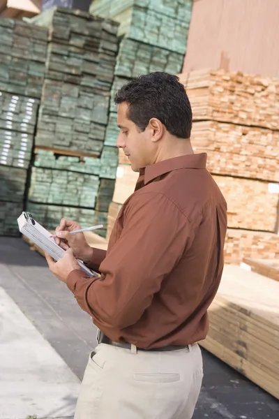 Male supervisor stock taking in warehouse — Stock Photo, Image