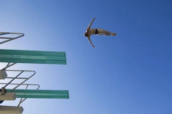Człowiek skoki do wody z trampoliny — Zdjęcie stockowe